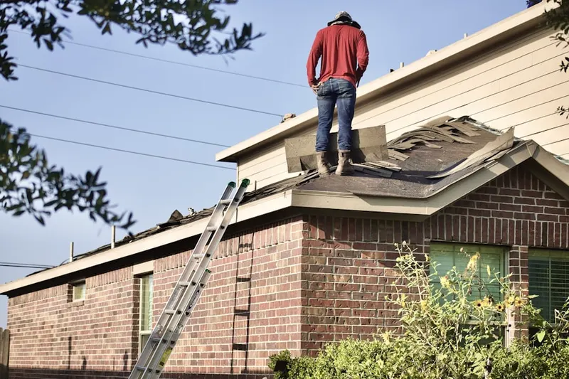 Professional roofer working on a residential roof in Plum